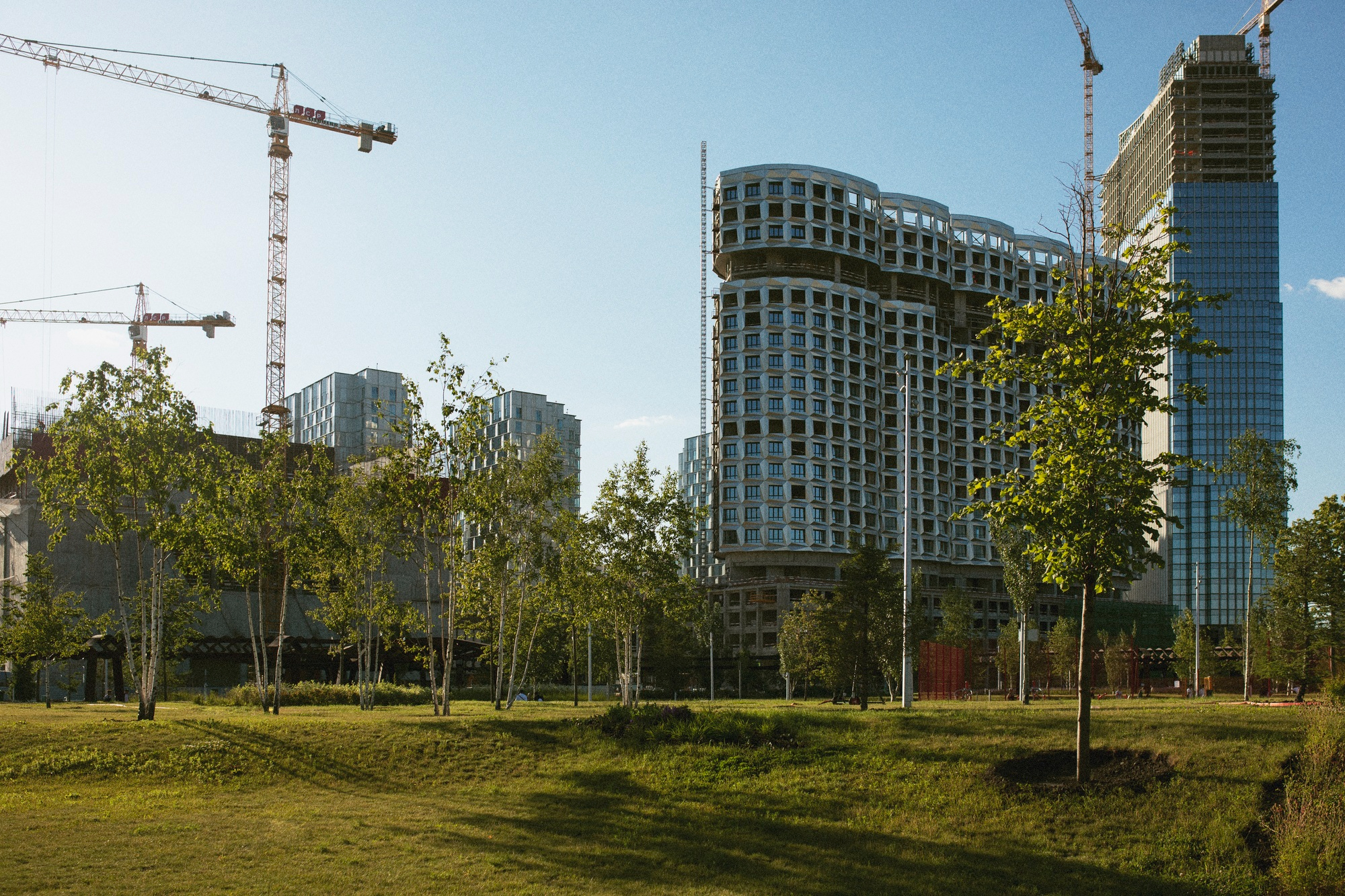 High-rise buildings under construction with cranes towering overhead.